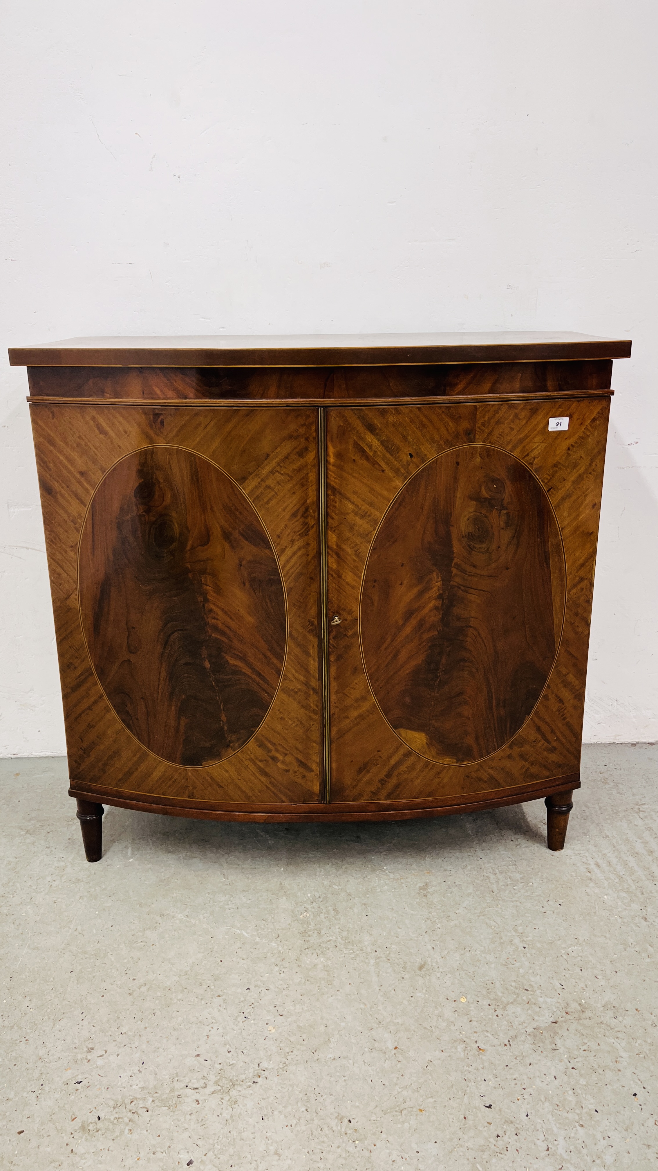 A C19TH. BOW FRONTED TWO DOOR CABINET IN LATE C18TH. STYLE WIDTH 104CM.