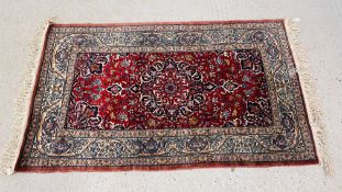 A PERSIAN STYLE RUG ON A MAINLY RED BACKGROUND, W 97CM X L 160CM.