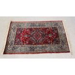 A PERSIAN STYLE RUG ON A MAINLY RED BACKGROUND, W 97CM X L 160CM.