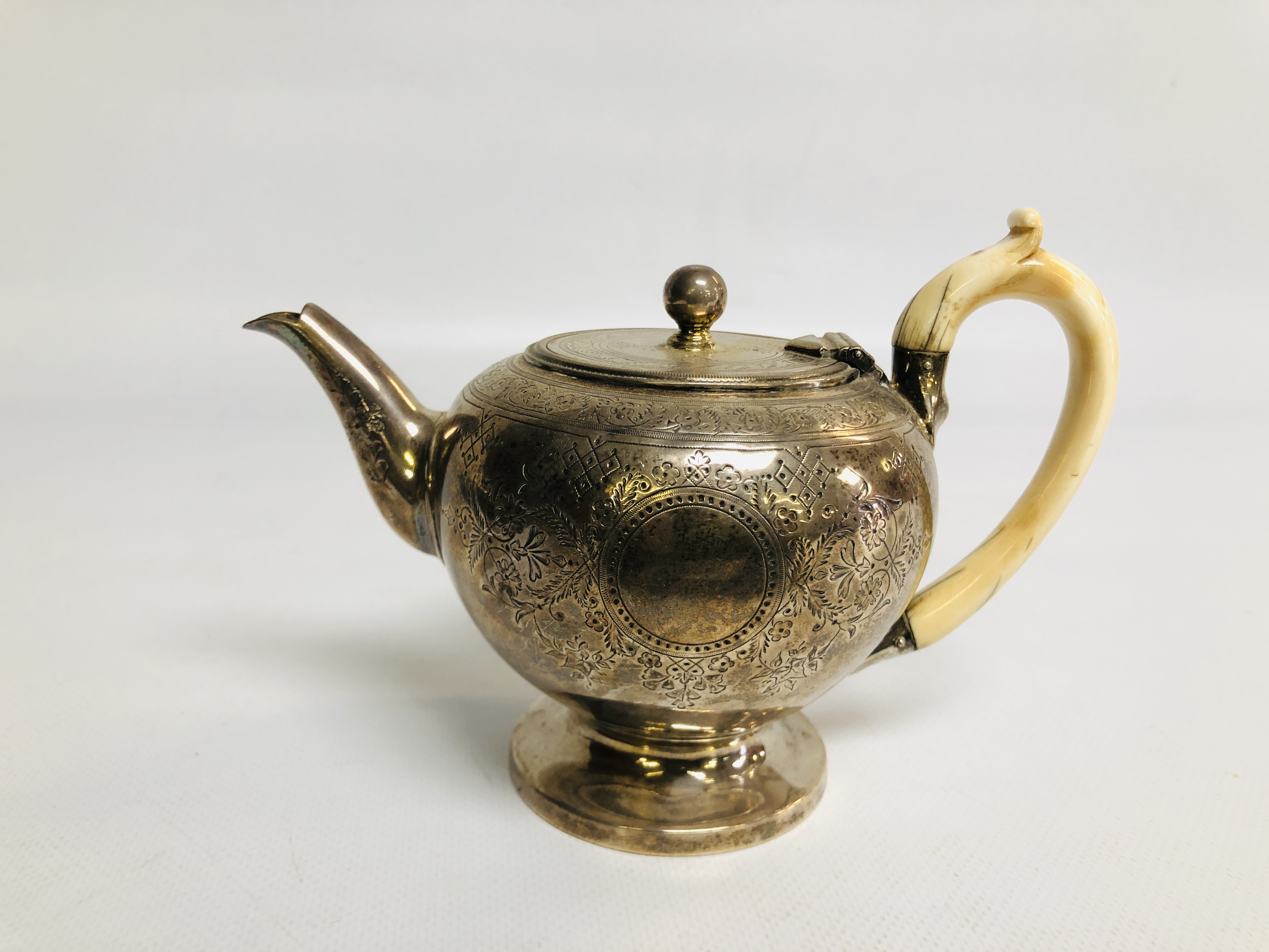 A VICTORIAN SILVER TEAPOT OF OVOID FORM THE BODY WITH VACANT CARTOUCHUS WITH IVORY HANDLE, BY G.