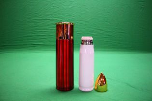 A WHITE 500ML BULLET FLASK ALONG WITH OVERSIZED 12G CARTRIDGE FLASK IN RED