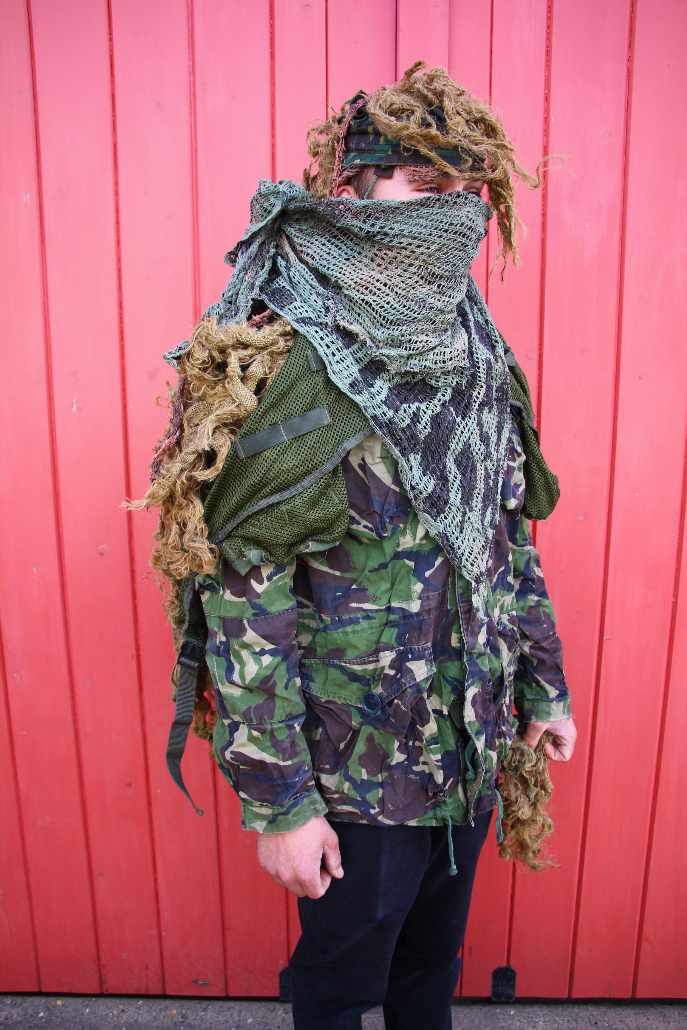 A CAMOUFLAGE GILLIE SUIT IN CANVAS CAMO BACK PACK