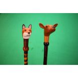 2 X HAND CRAFTED SHOOTING STICKS WITH CARVED AND PAINTED ANIMAL HEADS OF FOX AND DEER