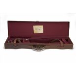 A BRASS-CORNERED LEATHER SINGLE GUNCASE, fitted for 30in. barrels, the interior lined with maroon