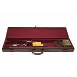 A LEATHER SINGLE GUNCASE, fitted for 30in. barrels, the interior lined with maroon baize, a pair