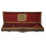 JAMES WOODWARD & SONS A BRASS-CORNERED OAK AND LEATHER SINGLE GUNCASE WITH PROVISION FOR EXTRA