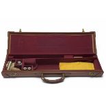 A LIGHTWEIGHT LEATHER SINGLE GUNCASE, fitted for 26in. barrels, the interior lined with maroon