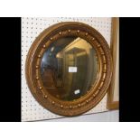 A circular convex wall mirror