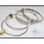 Four silver bangles, three engraved