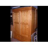A large pine wardrobe enclosed by a pair of panell