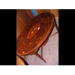 An antique oval coffee table with decorative marqu