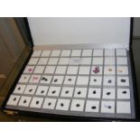 Twenty-nine square gemstone containers , some labe