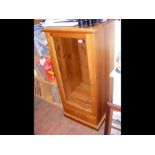 A glazed pine display cabinet with drawer below