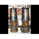A pair of vintage miner's lamps, with badge impressed