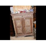 An antique ornately carved oak court cupboard with