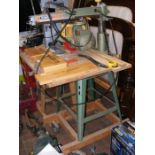 A DeWalt DW110 radial arm saw on workbench with spare FreudPro blade