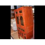 A Chinese red lacquered wedding cabinet with decorative hand painted panels and drawer fronts, measu