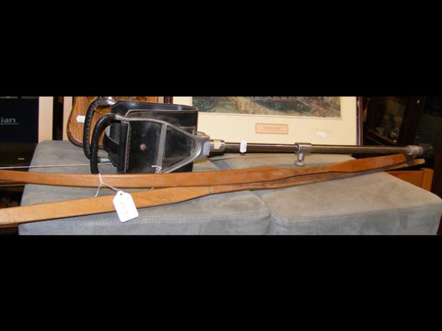 A shooting stick, together with two wooden bows
