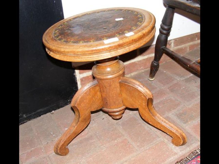 An antique piano stool with relief work leather to