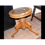 An antique piano stool with relief work leather to