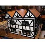 A doll's house in the form of a Tudor cottage