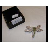 A silver brooch in the form of a moth set with per