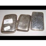 A silver cigarette case together with two others