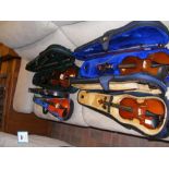 Four modern violins in carrying cases