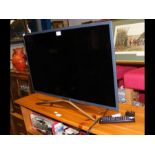 A Samsung UE32M5520AK 31" TV with power cable and