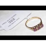 A three stone ruby and diamond ring in gold settin