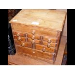 A miniature wooden multi-draw chest