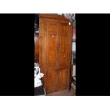 A large oak corner cabinet with panelled doors - s