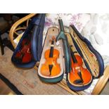 Three student violins - in cases