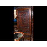 A Chinese hardwood wardrobe with carved door and s