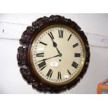 A Victorian circular wall clock with carved surrou