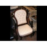 A Victorian nursing chair with decoratively carved