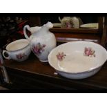 An antique jug and bowl set together with matching