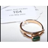 A .585 gold ring set with baguette emerald
