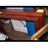 A red lacquered carved fire surround