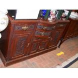 A bow front sideboard with decorative carved panel