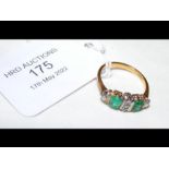 An 18ct gold ring set with emeralds and diamonds