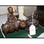 An oriental bronze of child riding pig - 12.5cm hi