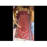 Two red ground Middle Eastern style rugs, one 180c