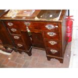 An antique walnut writing desk with seven drawers