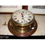 An old brass cased ship's bulkhead clock with sepa