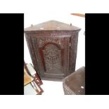 A carved antique corner cupboard