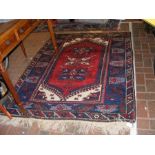 A decorative Turkish carpet with red ground and ge