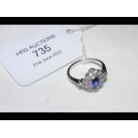 A lady's platinum diamond and sapphire ring in ele