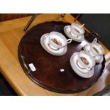 An oval mahogany tray together with four cups and