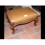 A small footstool with cabriole supports